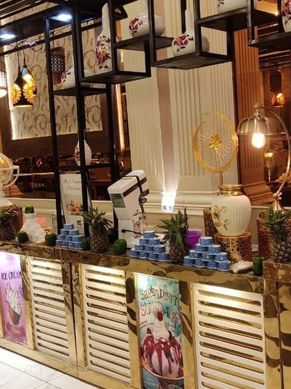 A modern and stylish buffet counter with overhead shelving and decorative lighting. This setup is perfect for serving desserts and drinks, adding a contemporary flair to the event.