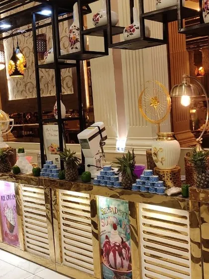 A modern and stylish buffet counter with overhead shelving and decorative lighting. This setup is perfect for serving desserts and drinks, adding a contemporary flair to the event.
