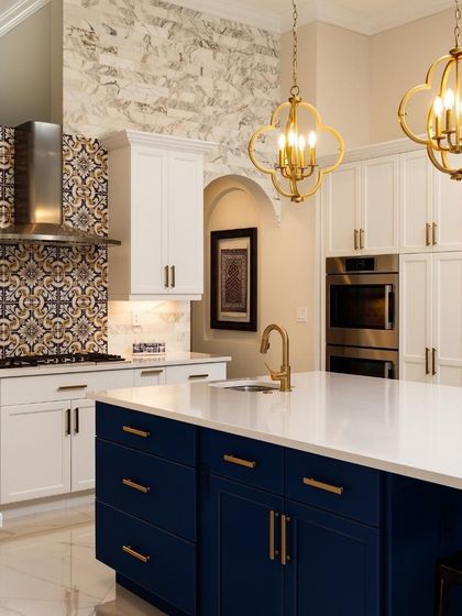 This kitchen blends classic and modern elements seamlessly. The navy blue island, white shaker cabinets, and patterned tile backsplash work together to create a bold and harmonious design.