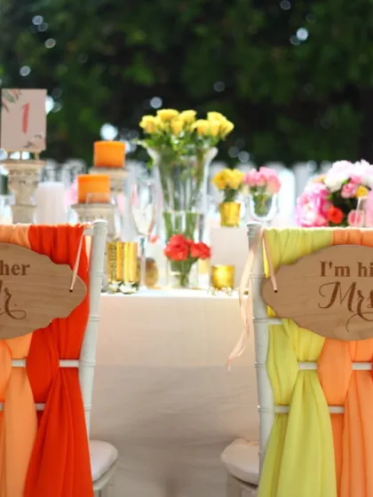 A charming "Mr & Mrs" sign on the chairs of the bride and groom, set against a colourful and vibrant table. We help add those personal touches that make your wedding day unique.