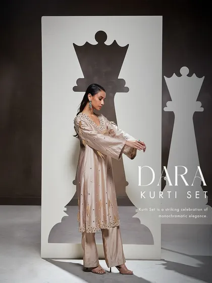 My Dara Kurti Set is a celebration of monochromatic elegance. This fusion silhouette features a stunning kurti and sharara adorned with exquisite hand embellishments.
