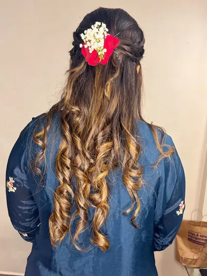 Soft curls with a braided crown and floral accessories. This hairstyle is perfect for an Indo-western outfit.