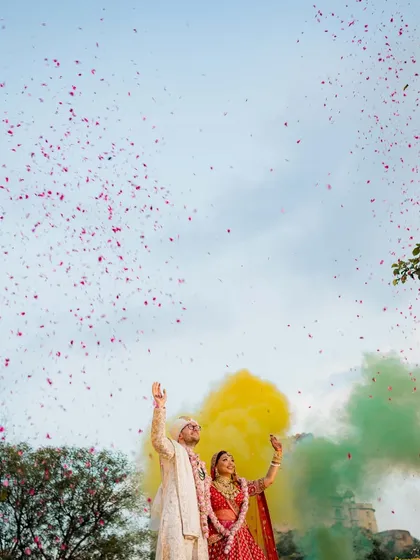 A moment of pure magic against the sky. This isn't just a photo; it's the climax of a fairytale. We use elements like colored smoke and a shower of petals to create grand, cinematic visuals that feel as epic as your love story. This is how we turn a destination into a breathtaking memory.