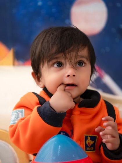 A close-up of our little astronaut, looking up in wonder. This shot captures the curiosity and imagination that this theme inspires.