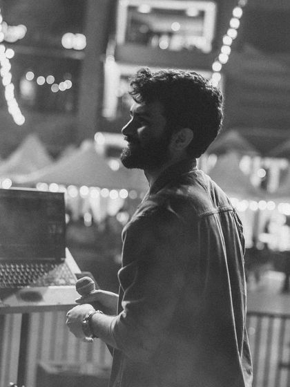A side profile in black and white, with the stage lights creating a beautiful bokeh. A quiet moment before the next song.