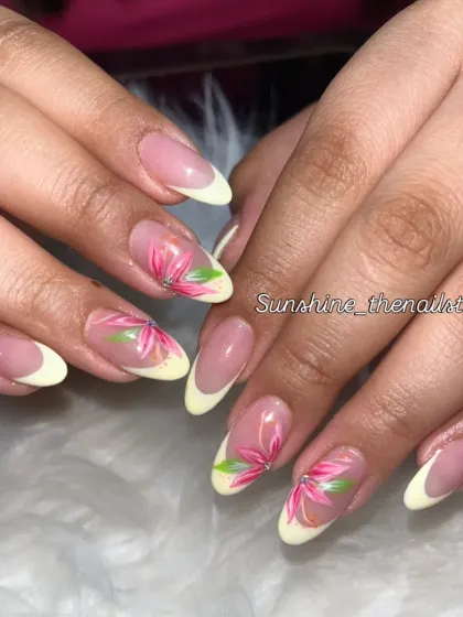 A pastel yellow French manicure with hand-painted pink flowers.
