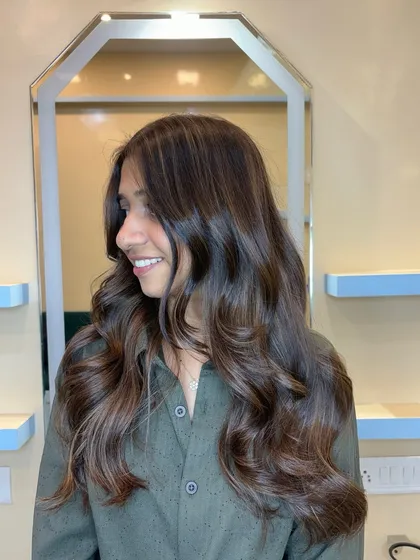 The beige blonde highlights catch the light beautifully against the light brown base, creating a soft and sophisticated look.