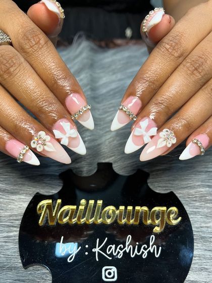 An angelic stiletto nail set with a white ombre base, accented with 3D bows and rhinestone bands.