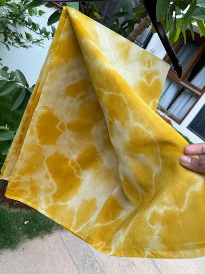 A close-up showing the texture and flow of the hand-dyed silk cotton saree. The fabric is light and airy, making it comfortable to wear.