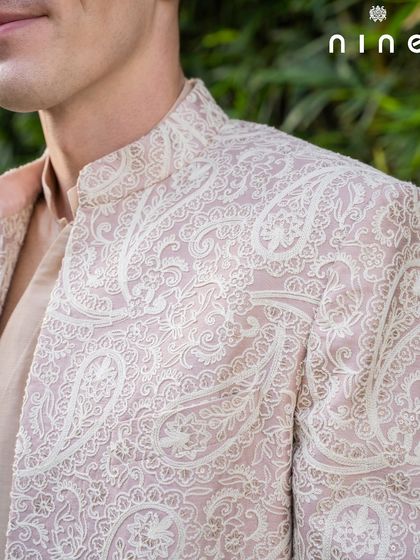 The shoulder and collar detail of our Mughal-inspired sherwani. The subtle, self-patterned embroidery adds a layer of texture and richness without overwhelming the clean silhouette.