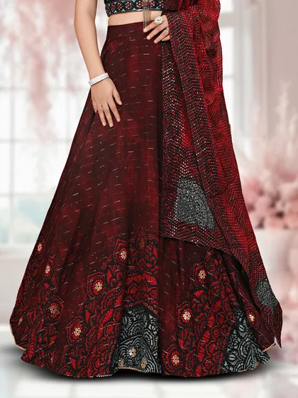 A detailed shot of the maroon lehenga skirt, showing the intricate patterns and sequin work.