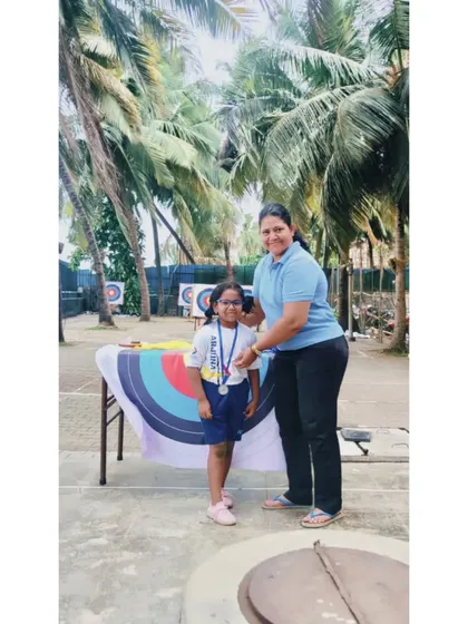 A young girl smiles as she receives her medal. Our intraclub events are designed to be encouraging and positive for all.