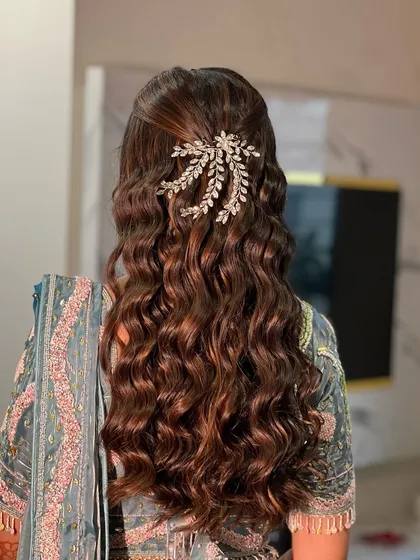 A beautiful open hairstyle with soft, romantic waves, adorned with a sparkling hair accessory for an engagement look.