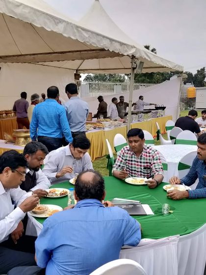 Guests enjoying a delicious meal at an outdoor corporate offsite event we catered. We provide complete seating and dining solutions to ensure comfort and convenience.