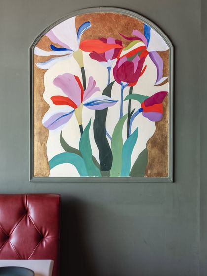 Another view of the hand-painted floral panel. The composition is designed to feel both structured within its arch and wild in its bloom, complementing the deep green walls.