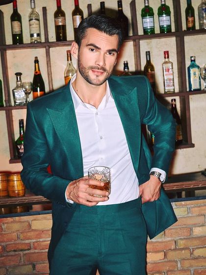 A confident portrait that captures the vibrant mood of the green linen suit. This is the perfect look for a man who wants his style to reflect his personality.