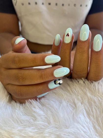 A playful and quirky summer design. This set features a cool minty blue base with tiny hand-painted hearts and a cute penguin accent nail.