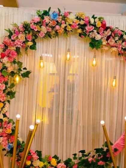 I specialize in modern backdrops for engagements and receptions. This circular ring arch, decorated with pastel flowers and lit with Edison bulbs, is a popular choice for a chic and stylish event.