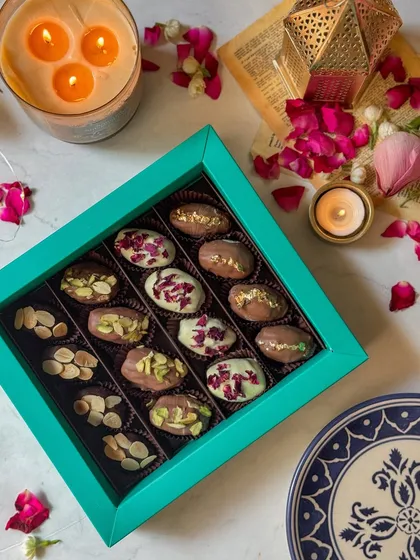 A luxurious turquoise box filled with an assortment of my premium stuffed dates. Toppings include pistachios, almonds, and dried rose petals, making each one a unique bite of indulgence.