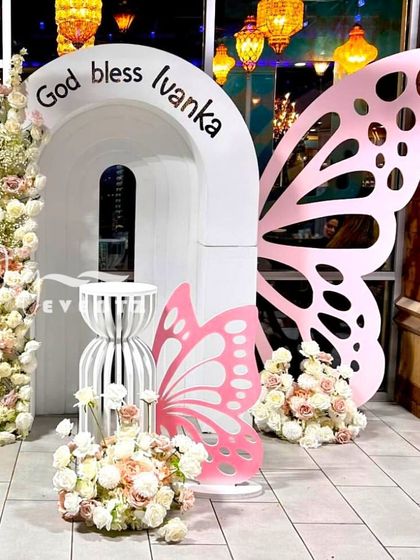 This butterfly-themed decoration for a First Holy Communion shows our modern and creative approach. The design uses custom-cut butterfly wings, elegant white arches, and beautiful floral towers for a whimsical and blessed celebration.