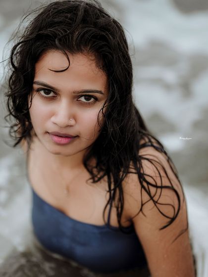 An intense and captivating look from a beach session. The focus is entirely on the model's expression, framed by the soft, natural light.