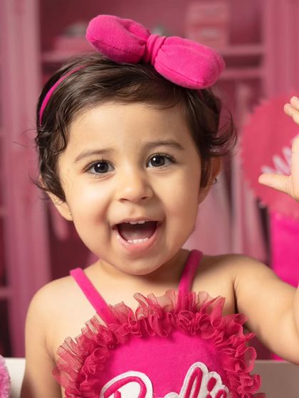 A series of close-up portraits showing the many adorable and happy expressions of a little girl during her Barbie-themed session.