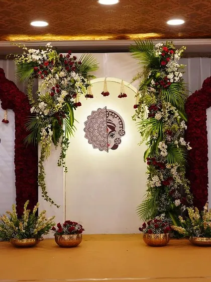 Another angle of the 'Mitakshi' stage, highlighting the symmetry of the design with floral-topped arches and peacock panels flanking the central deity artwork.