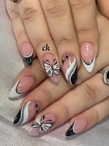 A beautiful hand-painted set with black and white French tips and butterfly accents.