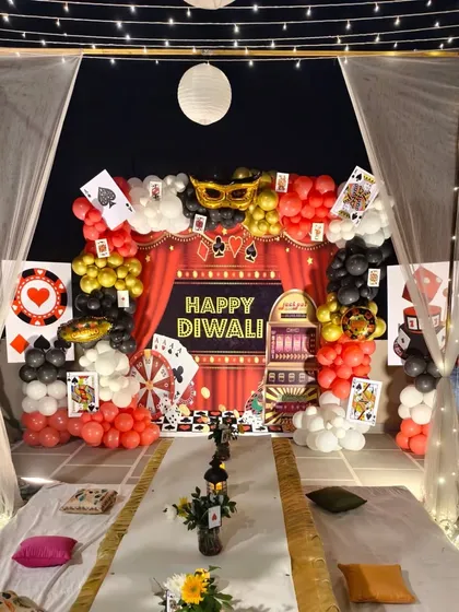 A full view of the casino-themed photo booth for a Diwali party, complete with a red curtain backdrop and card-themed props.