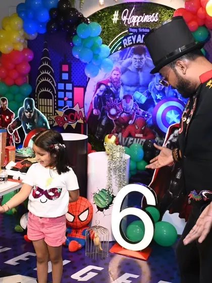 A young guest becomes my magical assistant. I use simple, visual tricks like this floating ball to amaze the little ones and give them a chance to be part of the show.