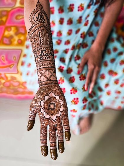 A classic bridal design featuring a large mandala on the palm and traditional bands on the arm.