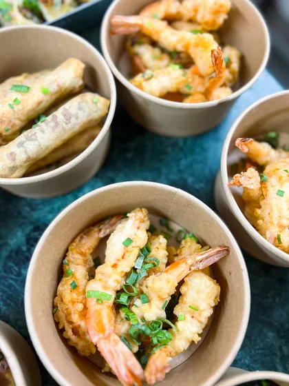 Crispy tempura prawns and spring rolls, packed in individual bowls for a party. This is a great way to serve appetizers for a casual get-together.