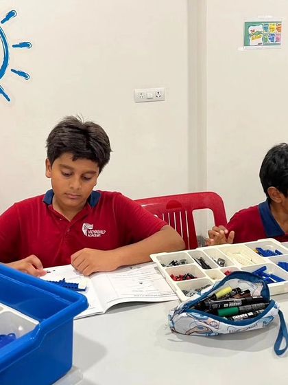 Two students from Vidyashilp Academy are focused on their build, demonstrating the concentration our programs inspire.