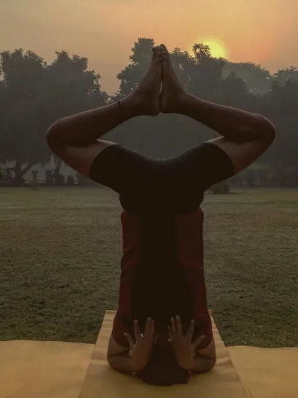 Baddha Konasana (Bound Angle Pose) legs in Sirsasana (Headstand) against a sunrise. This beautiful variation opens the hips while inverted, combining grounding and uplifting energies.