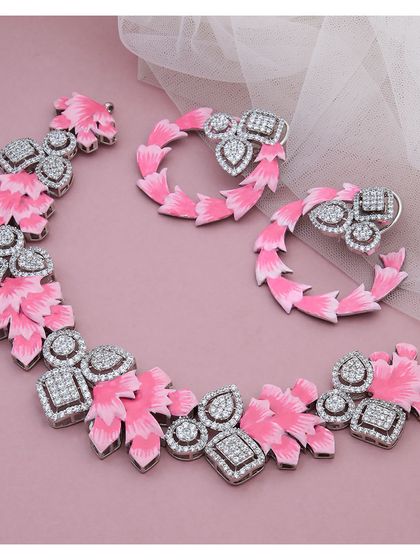 This fashion jewellery set makes a bold statement with its vibrant pink enamel and sparkling diamonds. The design features a floral-inspired necklace and matching hoop earrings, perfect for adding a pop of color and personality.