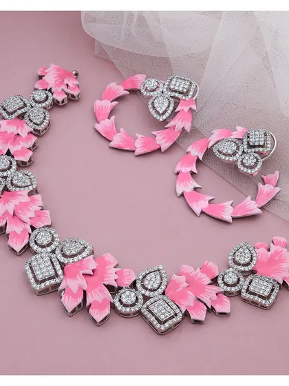 This fashion jewellery set makes a bold statement with its vibrant pink enamel and sparkling diamonds. The design features a floral-inspired necklace and matching hoop earrings, perfect for adding a pop of color and personality.