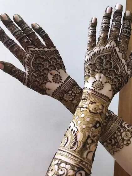A full-coverage design that tells a story. This intricate mehendi features delicate floral work on the forearm and classic mandala patterns on the palm, all coming together for a truly stunning look.
