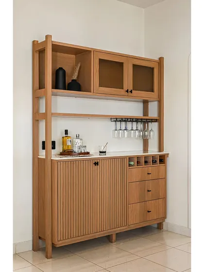 This custom-made bar and crockery unit is a perfect example of bespoke furniture. It features fluted details, a wine rack, glass storage, and frosted glass cabinets, all crafted from light oak for a modern, functional piece.