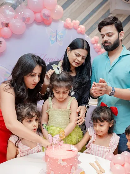 A family gathered around to help the birthday girl cut her butterfly cake. These are the sweet, shared moments that I love to be a part of.