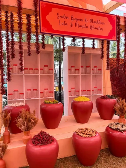 A custom-designed spice stall, complete with a Hindi sign, adds a playful and interactive element for guests at the 'Souk Bazaar' Haldi.