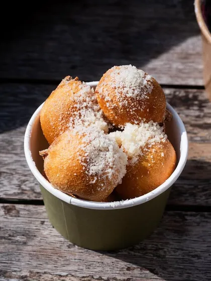 Truffle croquettes from La Tua Pasta, dusted with cheese and captured in bright sunlight. The shot feels fresh, summery, and delicious.