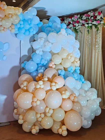 A detailed view of the organic balloon garland, showing the blend of colors and sizes used to create the cloud-like texture.