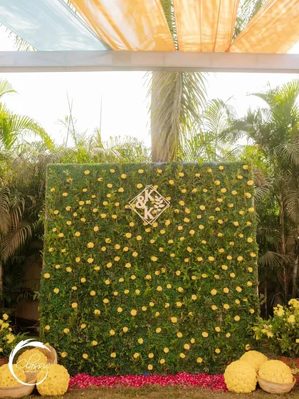 I love creating personalized photo booths. This one for a Haldi ceremony features a lush wall of greenery dotted with yellow flowers and the couple's custom 'K&K' monogram.