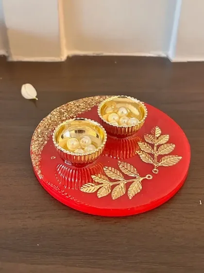A close-up of my red resin Rakhi thaali, adorned with golden leaf motifs. It’s a perfect, compact thaali for performing the Rakhi ritual with style and grace.