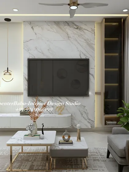 The TV unit in this Pune 2BHK is set against a stunning marble wall. The clean lines of the console and the gold-accented coffee tables create a look of understated elegance.