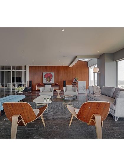 The living room at Sky Residence, designed as a sophisticated space for entertaining. I used a mix of iconic pieces, like the Eames lounge chairs, with comfortable modern sofas and a dark marble floor to create a layered, mid-century inspired aesthetic.