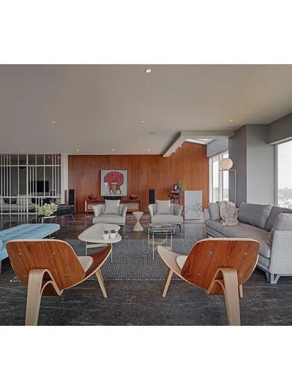 The living room at Sky Residence, designed as a sophisticated space for entertaining. I used a mix of iconic pieces, like the Eames lounge chairs, with comfortable modern sofas and a dark marble floor to create a layered, mid-century inspired aesthetic.