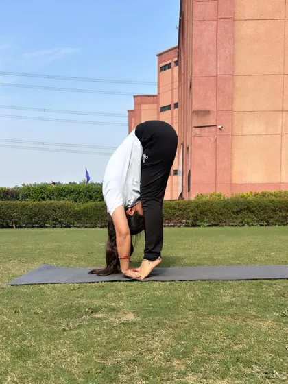 A moment of stillness in a standing forward bend. This pose is excellent for calming the nervous system and releasing tension in the hamstrings and lower back.