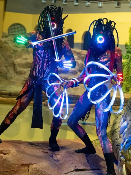 Our Alien theme is available as a duo act for a more interactive and large-scale performance. Here, two performers coordinate their poses with LED staffs and fans.