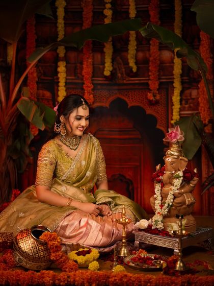 A wider view of the Ganesh Chaturthi setup, showing the vibrant colors of the marigold garlands and the traditional brass lamp.